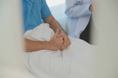 Genç doktor steteskop kullanıyor. Hastanın kalp atışlarını dinle. Kadın bir doktorun erkek bir hastaya muayene yaparken görüntüsü.