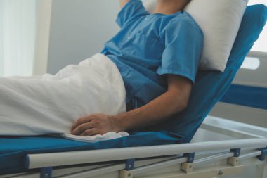 Hastanede bir yatakta yatan ciddi hasta adam. Monitörler yaşam belirtilerini gösteriyor. Ward's temiz ve yeni.