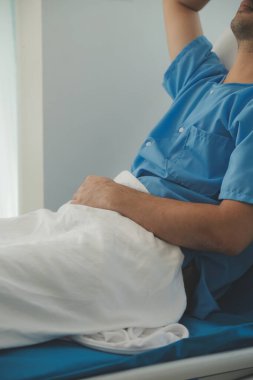 Hastanede bir yatakta yatan ciddi hasta adam. Monitörler yaşam belirtilerini gösteriyor. Ward's temiz ve yeni.