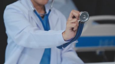 Yakın plan - kadın doktorun steteskop tutarken ve kameraya bakarken