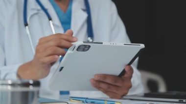 Doktor elinde dijital tablet tutuyor.
