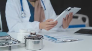 Doktor ofiste tablet bilgisayarla çalışıyor.