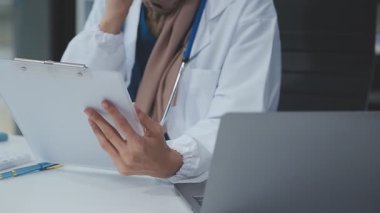 Masada steteskop ve tablet bilgisayarı olan bir doktor.