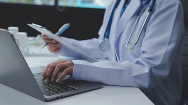 Doktorun elinde steteskoplu dijital tablet var.