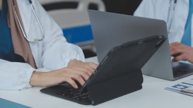 Doktor hastane ofisinde dizüstü bilgisayarla çalışıyor..