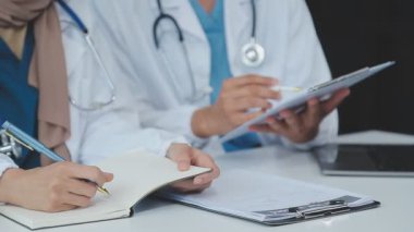Bayan doktorlar masada reçeteyi tartışıyorlar.