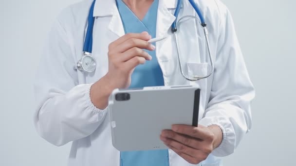 白い背景にデジタル タブレットが付いているタブレットを握る医者 — ストック動画