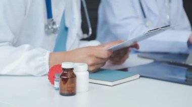 Doktor elinde reçete ve ilaç tutuyor.