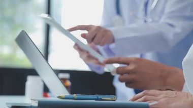 Doktor tableti tutuyor ve parmağıyla işaret ediyor