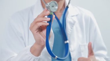 Doktor steteskop tutuyor, beyaz arka planda izole edilmiş.