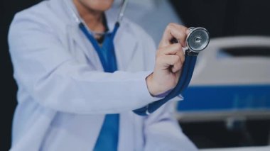 Doktor steteskop tutuyor ve bir hastayı muayene ediyor.