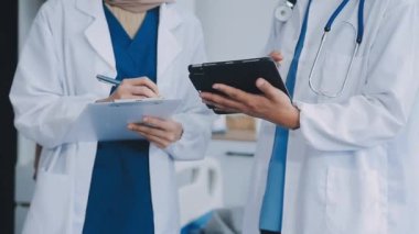 Doktorlar ofiste tıbbi kayıtları tartışıyorlar..