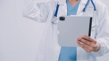 Doktor ofiste bir tablet bilgisayar tutuyor.