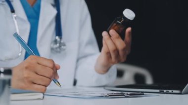 Doktor klinikteki iş yerinde panoya yazı yazıyor.