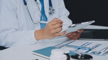 Doktor ofisinde bir tablet bilgisayar tutuyor.