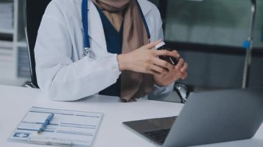 Doktor ofiste dizüstü bilgisayarla çalışıyor..