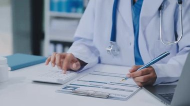 Doktor reçete tutuyor ve hastanede çalışıyor.