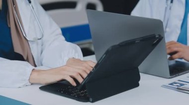 Hastane ofisindeki ofis masasında dizüstü bilgisayarda çalışan doktoru kapat..