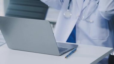 Yakın plan - İş yerinde dizüstü bilgisayar kullanan doktor elleri