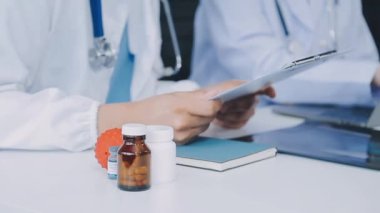 Doktorun elinde reçeteli ilaç şişesi var.
