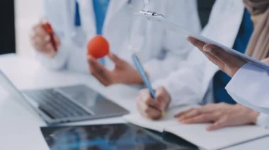 Doktor elinde dijital tablet tutuyor ve bir şeyi tartışıyor.