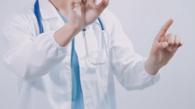 Genç doktor elini gri arka planda gösteriyor.