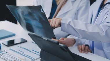Hastanedeki hastanın röntgenini tartışan doktorların yakın çekimi..