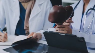 Doktor steteskop tutuyor, hasta da arka planda.