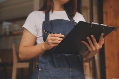 Başlangıçta başarılı olan küçük işletme sahibi, kafeterya restoranında elinde tablet akıllı telefonuyla güzellik kızı standı açmıştı. Kahveci Asyalı kadının portresi. KOBİ girişimci iş konsepti