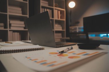 Laptop ve evraklar konferans masasında.