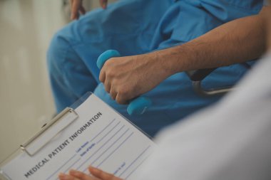 Egzersiz halter tedavi hakkında kol ve omuz sporcu ile erkek hastanın fizik tedavi kavramı veren fizyoterapist adam