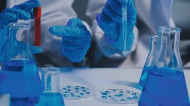 Laboratuvarda bir bardak su ile laboratuar bilimcisi.