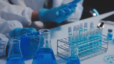 Laboratuvarda tüpü tutan bilimadamlarının elleri yakın plan