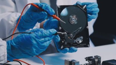 Yakın plan - bilgisayar diski tutan mavi kasklı bir adamın elleri..