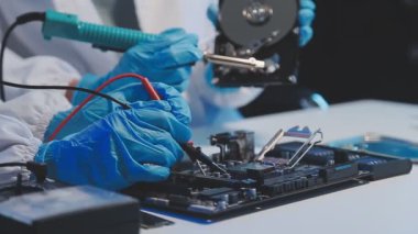 Laboratuvarda mikro devre kullanan eldivenli ve maskeli bilim adamı
