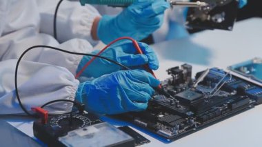 Laboratuvar önlüklü bilim adamı mikrodevre kartı ve mikro devre tutuyor.