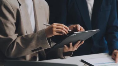 İşadamlarının ellerinin kalem tutuşu ve grafik grafiğine işaret etmesi.