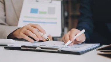 İşadamı eli kalemle grafiğe işaret ediyor