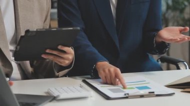 Finansal grafik ve rapor ile çalışan iş ekibi görevdeki dizüstü bilgisayarda.