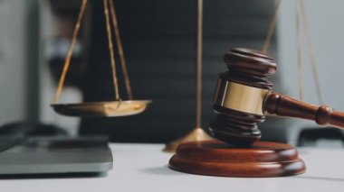 Yargıç tokmağı ve hukuk kitabı masada.