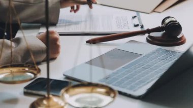 Avukat, iş yerinde dizüstü bilgisayarla ve belgelerle çalışıyor.