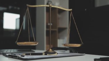 Adalet terazisi, tokmak ve masada kitaplar.