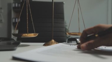 Hukuk, adalet kavramı. Tokmak, yargıç ve terazi, mahkeme salonundaki ahşap masada bir kalemle..