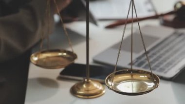 Avukat terazilerle, ofis masası belgelerle, terazilerle, adaletle, tokmakla, terazilerle, hukuk hizmetleri kavramlarıyla çalışıyor..