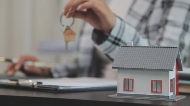 Ev modelini anahtarlar ve emlak konseptiyle masada tutuyoruz..