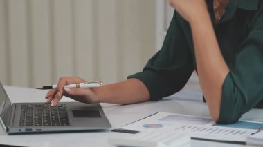 Bilgisayarlı bir ofiste çalışan genç bir kadın.
