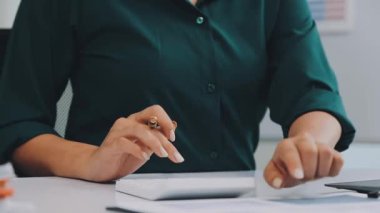 İş kadını ofis masasında dizüstü bilgisayar kullanıyor.