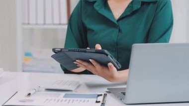 Ofiste dijital tablet ve laptop kullanan kadın.