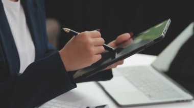 Tablet bilgisayarlı ve defterli bir iş kadını.