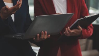 İş arkadaşları modern ofiste çalışmayı tartışıyor.